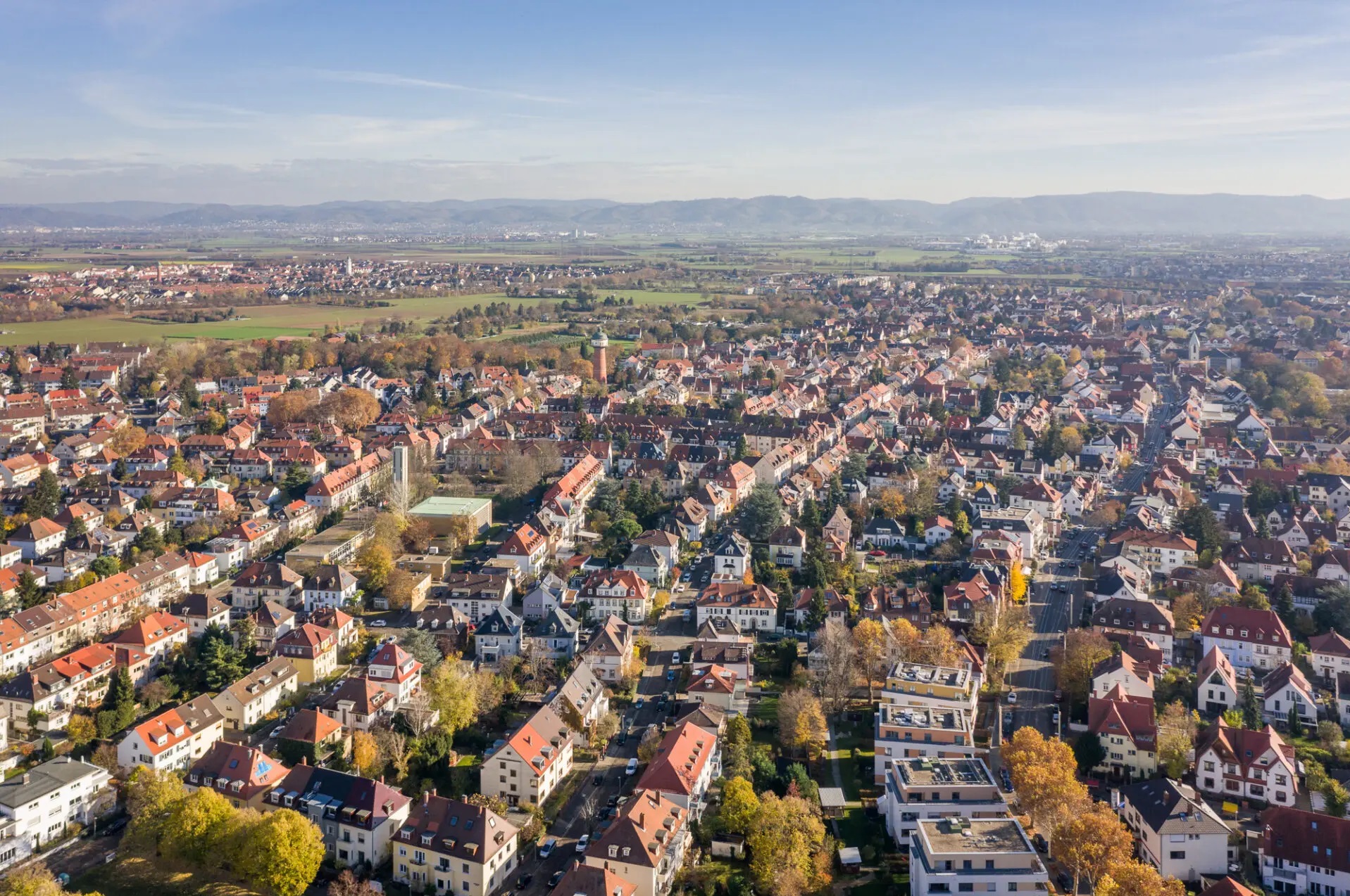 Luftaufnahme von Feudenheim mit Wohnhäusern, Feldern und Hügeln im Hintergrund